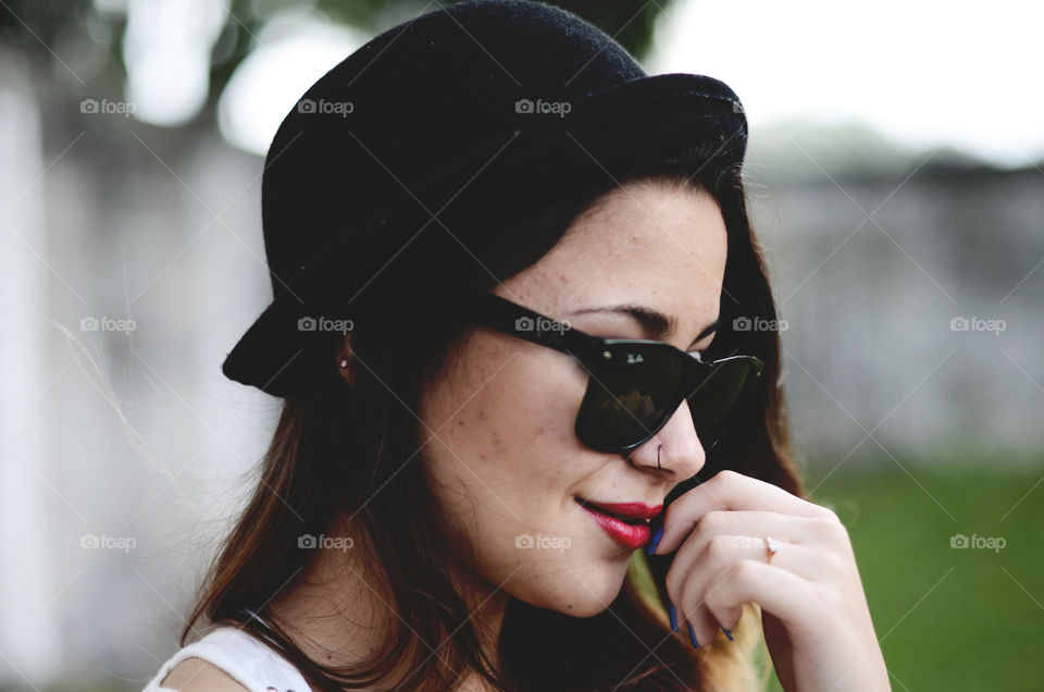 Headshot of a woman wearing hat and sunglasses