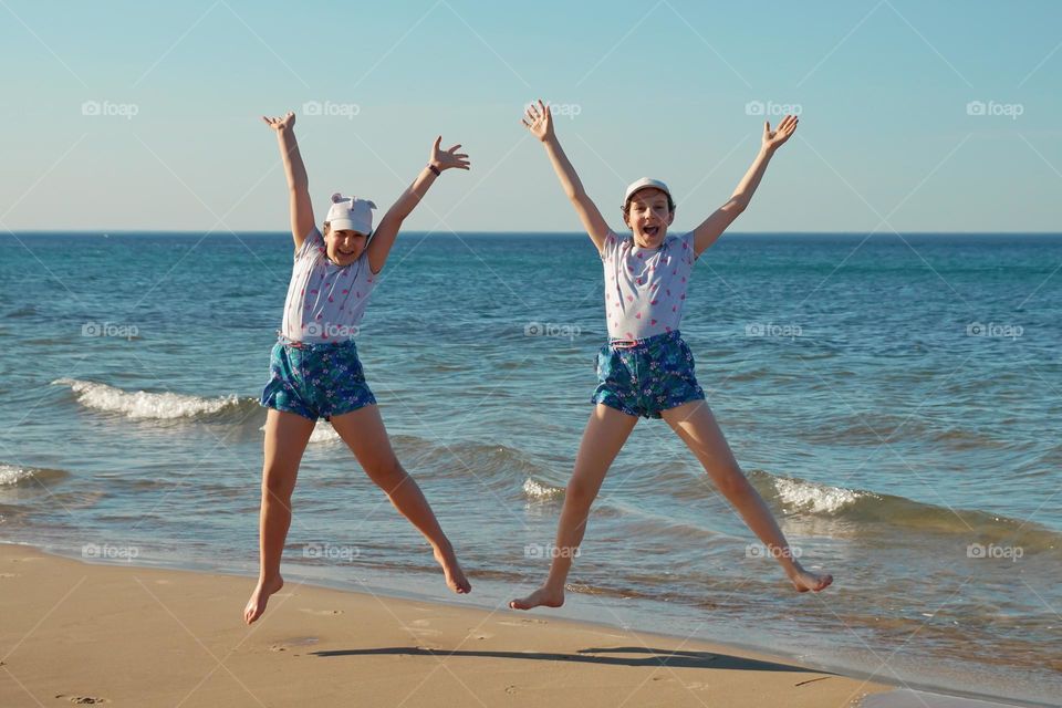 Children jumping on the seashore