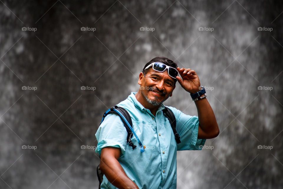 Happy man on a hike by the waterfall