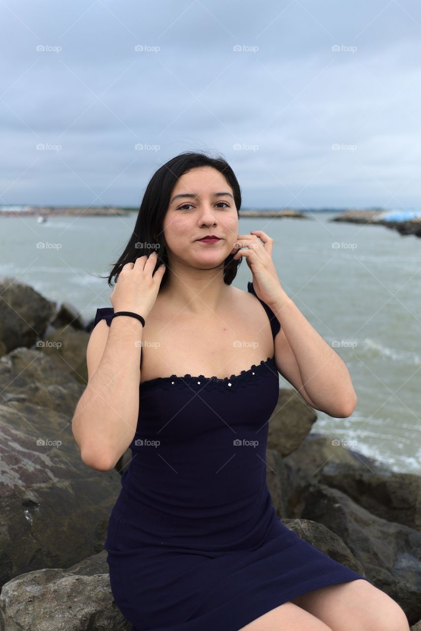 Young woman having her hair done in front of the sea