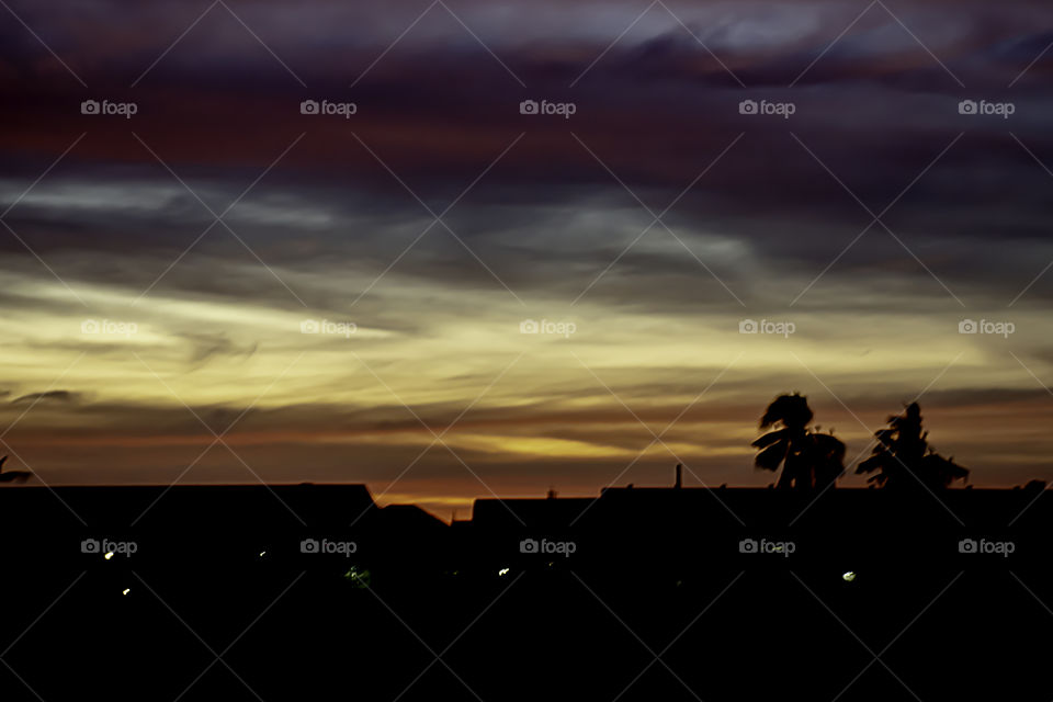 Beautiful light of Sunset with clouds in the sky reflection behind the building.
