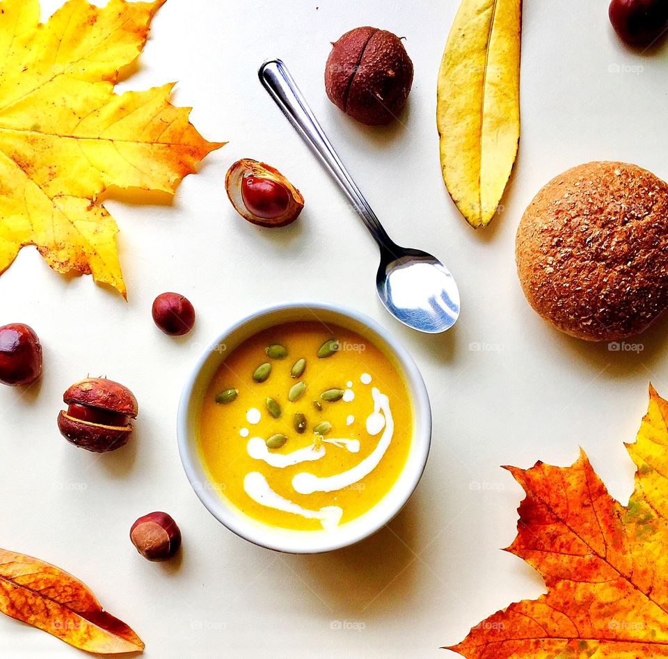 Pumpkin soup with pumpkin seeds on a white background 