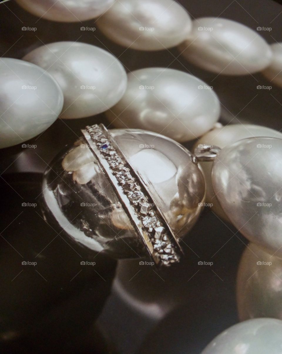 fotografía de joyería de collar de perlas color nacar con Perla de plata ley con un cinturón de diamantes.
