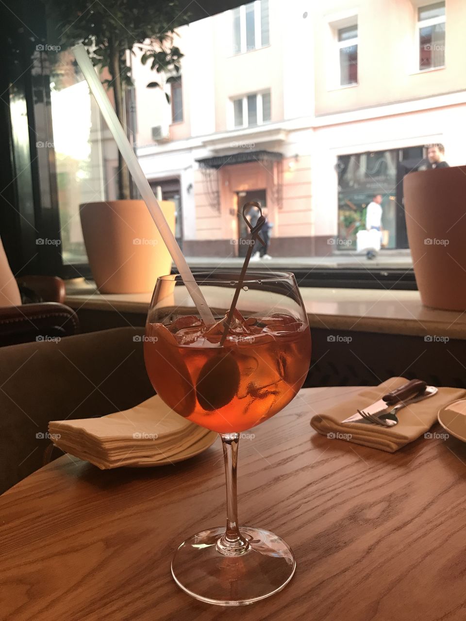 Summer city cafe view with aperol spritz cocktail and opening window 