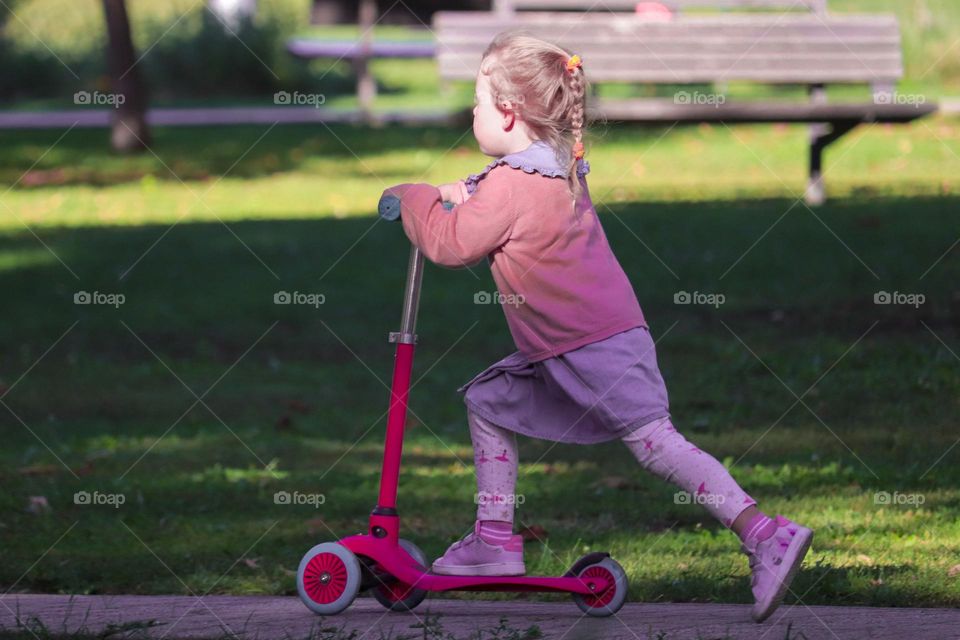 Girl riding a scooter at the park