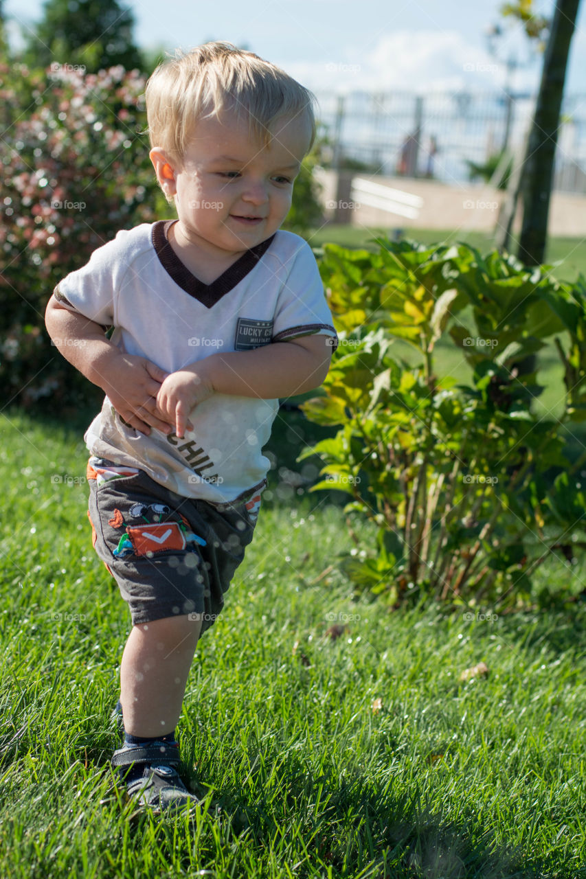 A little boy playing on grassy field