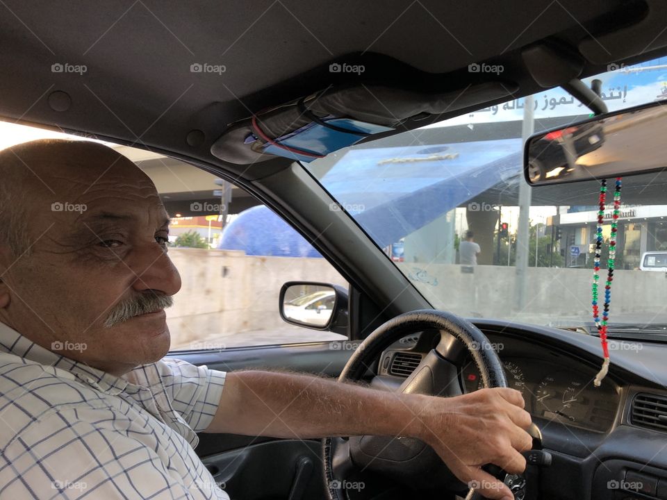 Old, tired, and hardworking taxi driver in Lebanon.