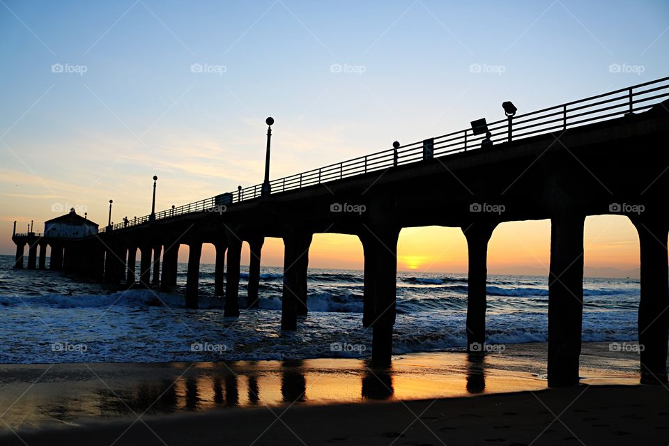Pier in sea during sunset