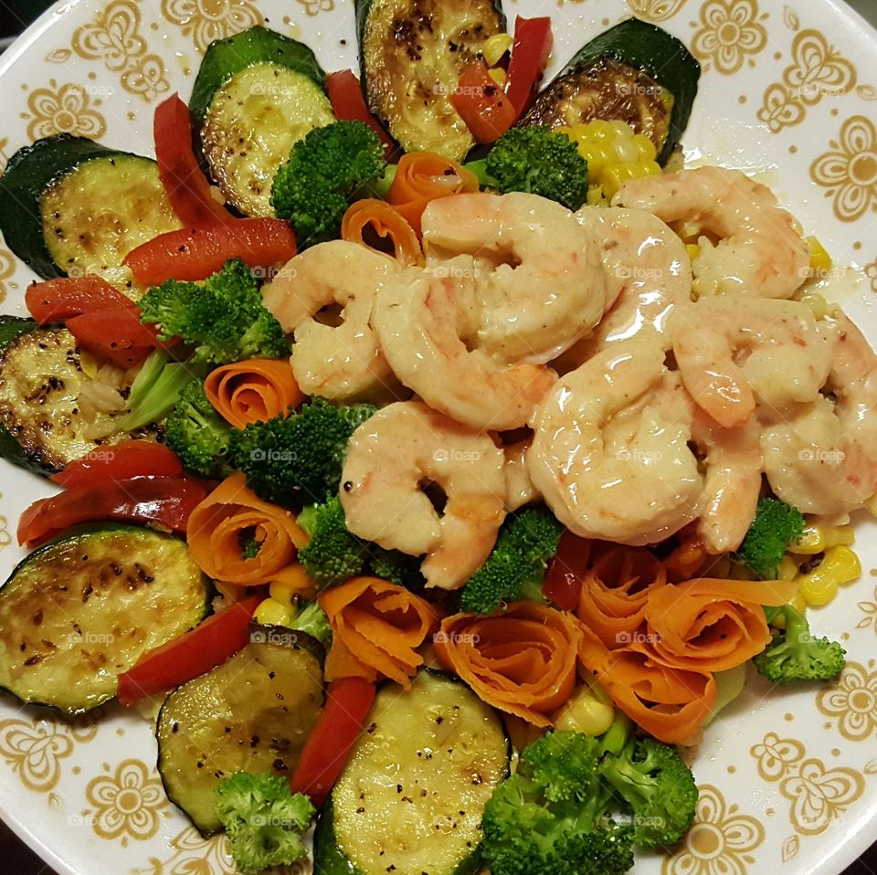Shrimp with garlic, butter and white wine sauce, served over  pan-seared zucchini, red pepper, carrot strips, corn, and broccoli.