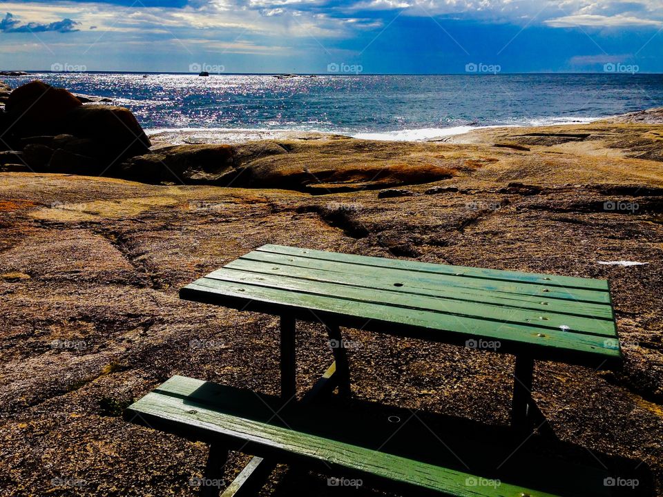 Empty wooden bench near sea