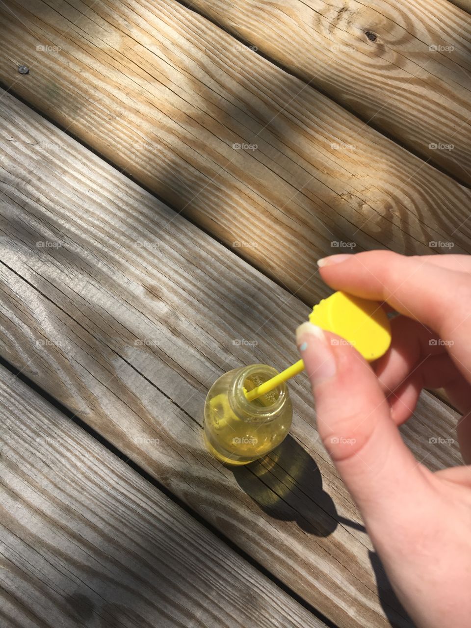Taking out bubble wand of yellow soda bottle container