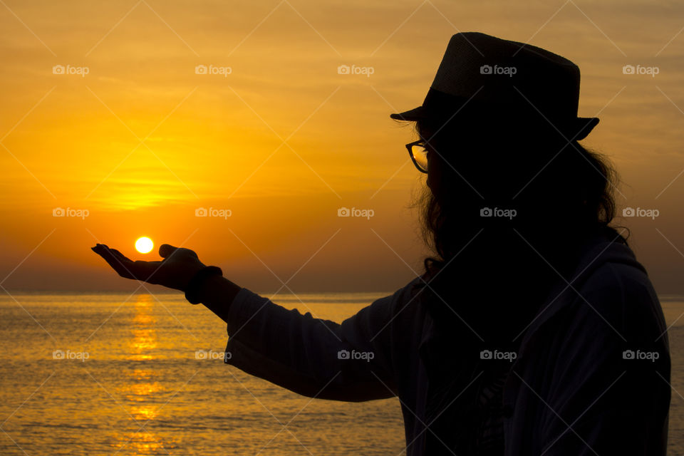 A woman's silhouette and sunset over the sea