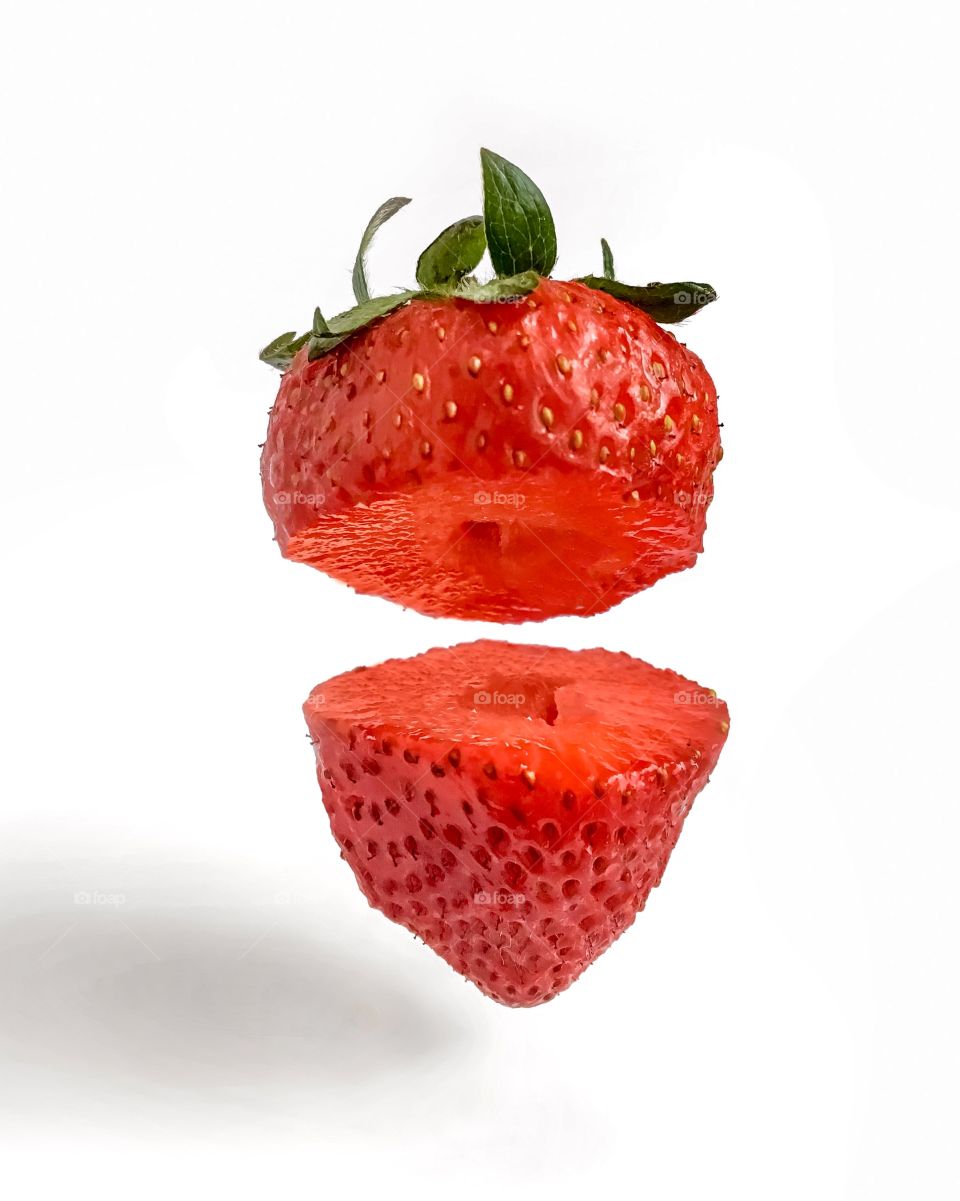Levitated cutting strawberry on white background 