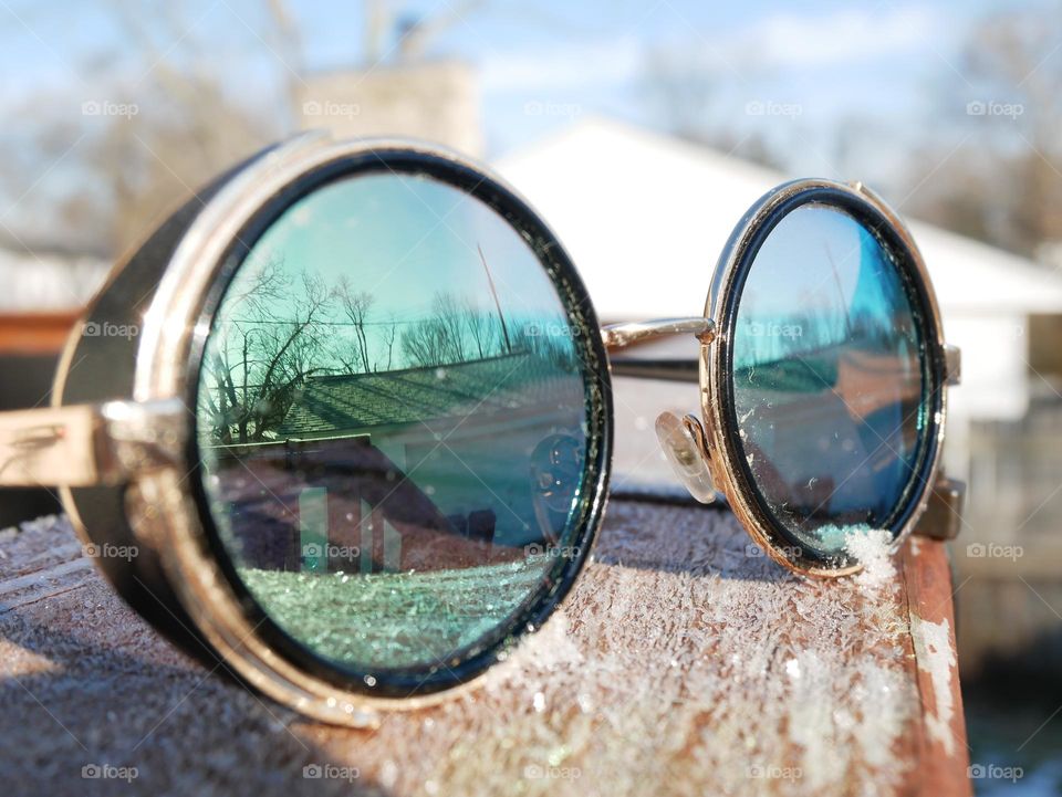 A pair of stylish, “hippy” glasses reflects the sun, on a bitterly cold but sunny morning. 