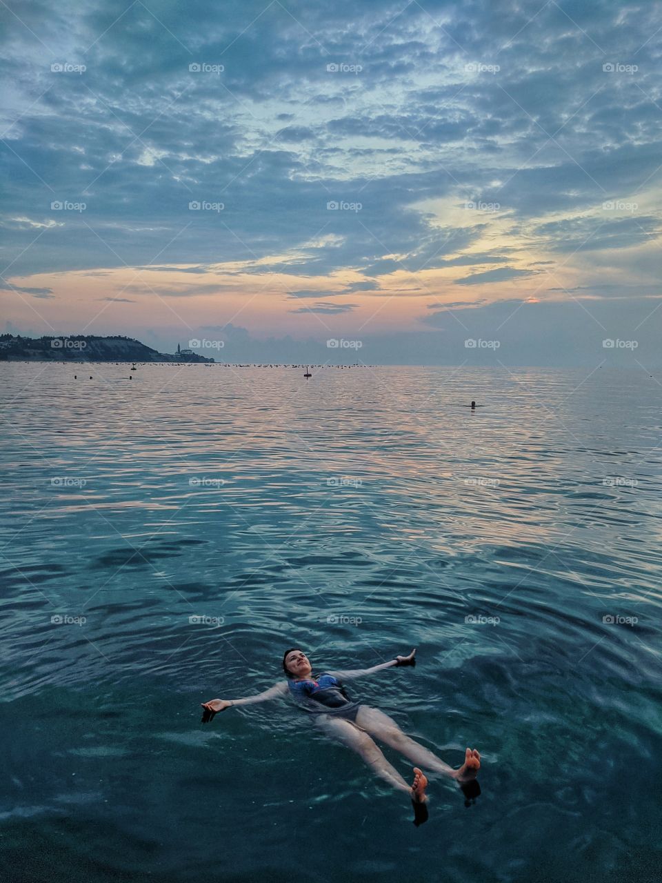 Happy woman swimming in the adriatic sea at the sunset.