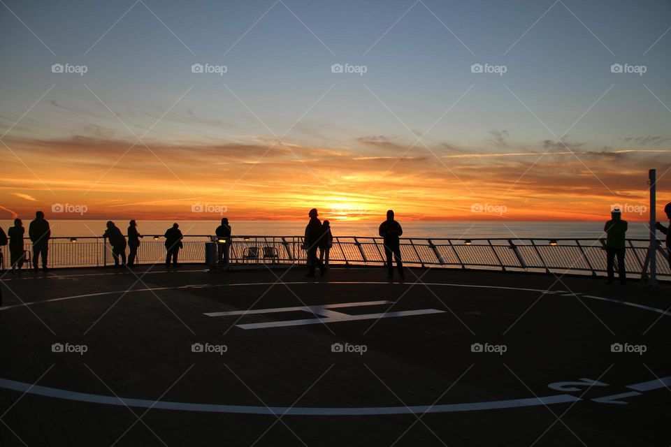 People on the deck of a ship at sunset