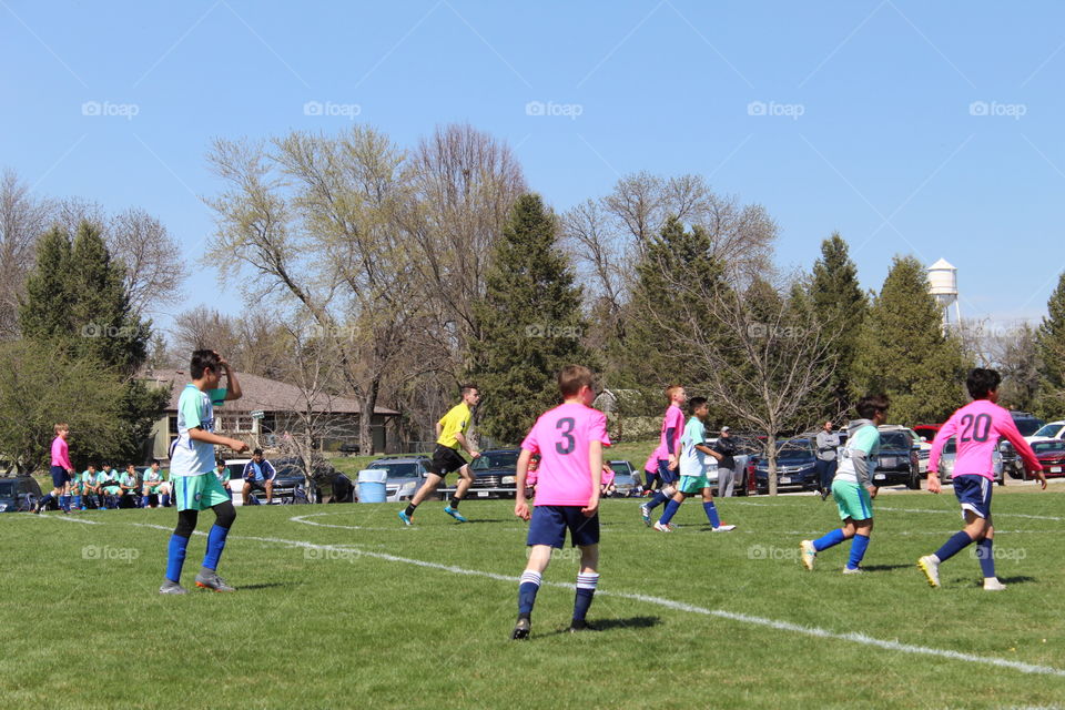 Kids playing soccer in a beautiful spring day.