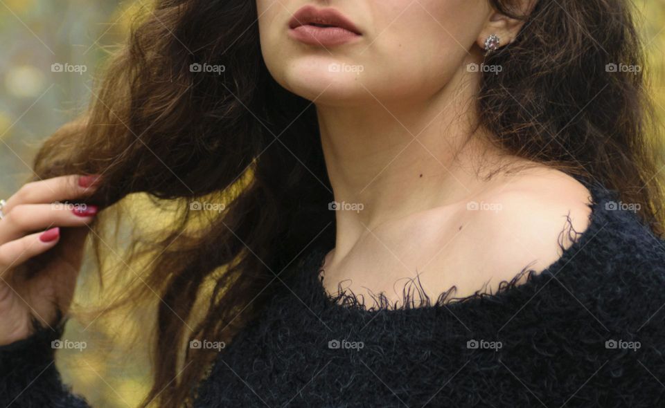 Girl with beautiful curly hair in the autumn park.