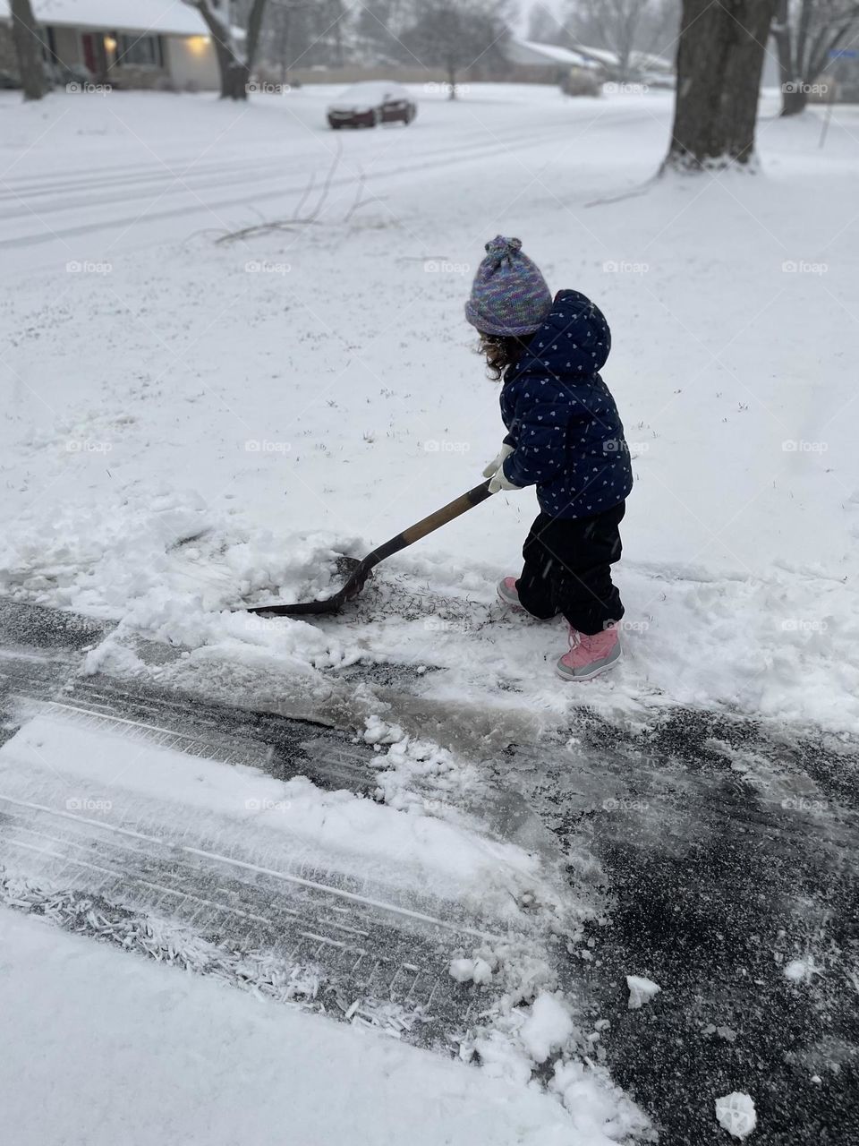 Toddler shovels snow in the winter, toddler helps mommy, toddler uses snow shovel, toddler girl in ice and snow storm 