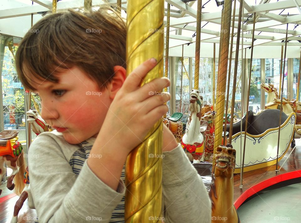 Young Boy Riding A Carousel