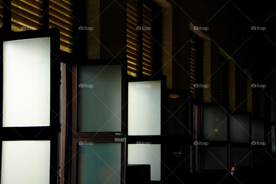 Portrait of a classic European style wooden window in a white-walled building, a green wooden window with white trim built during the Dutch colonial period in an old building in Jakarta.