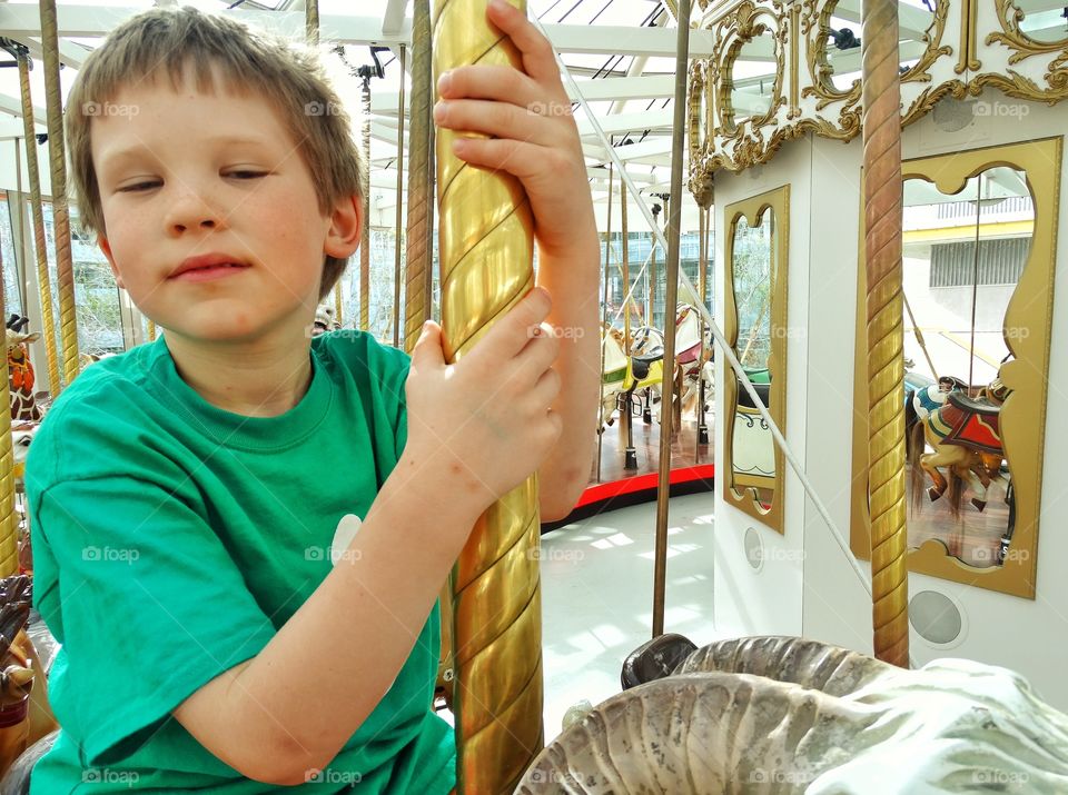 Boy Riding A Merry Go Round