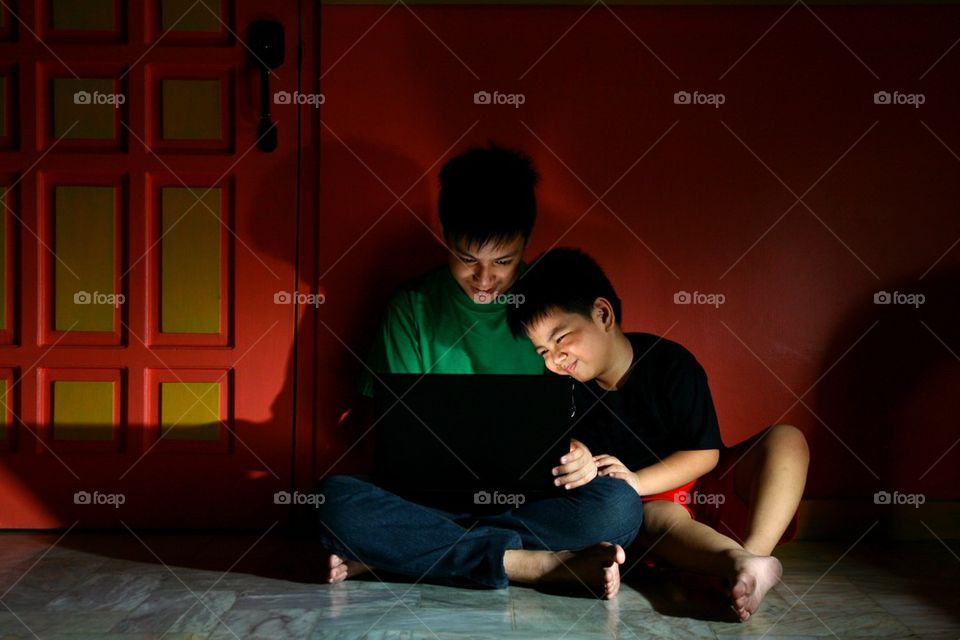 young asian children with a laptop computer in a living room