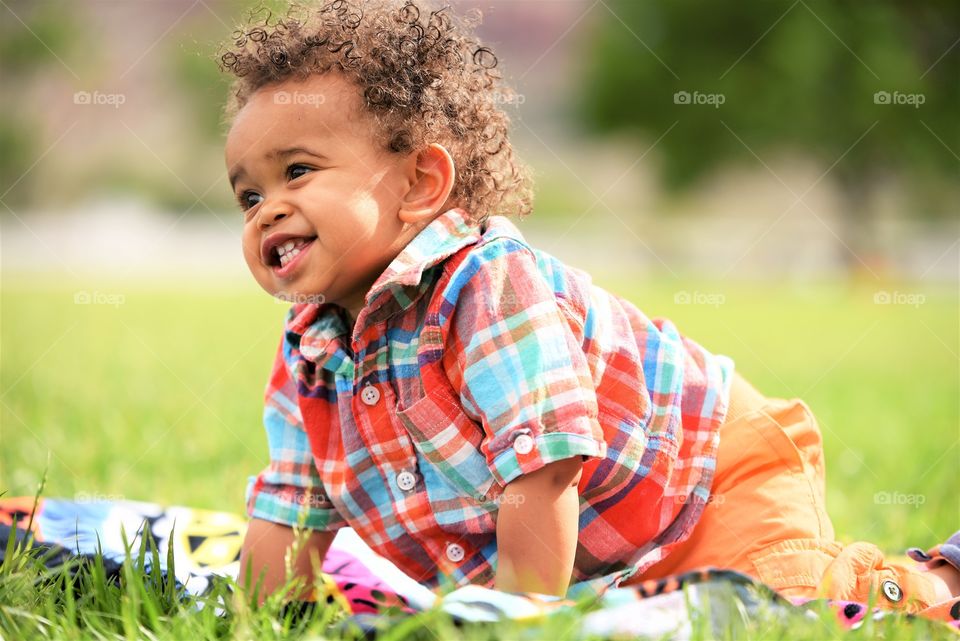 Baby one year bright happy smiling mixed race adorable fun outdoor colorful green