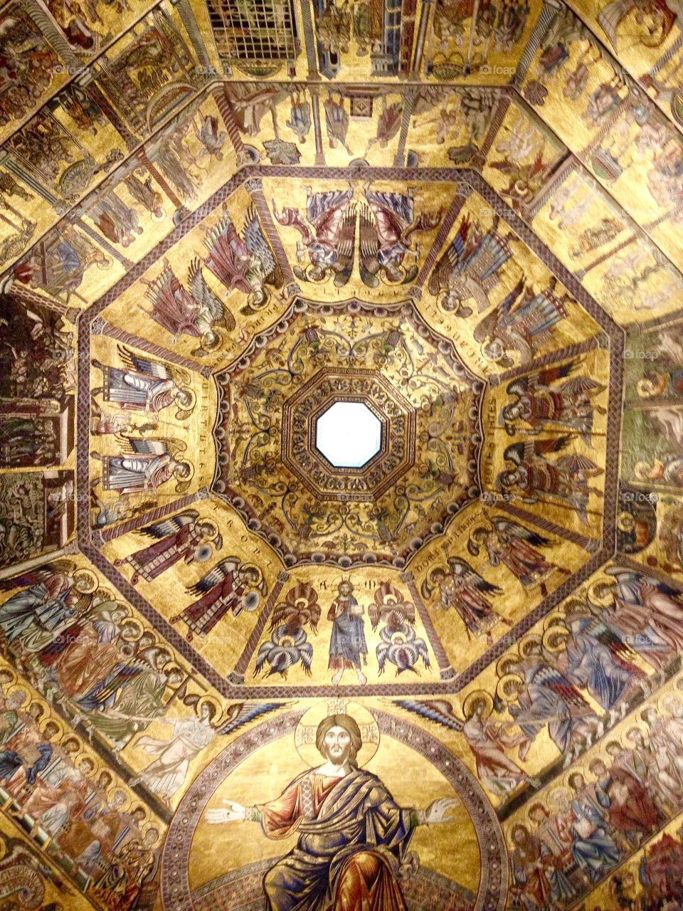 The interior dome of Florence Baptistery with gold mosaics of Christ, saints, angels, and biblical figures