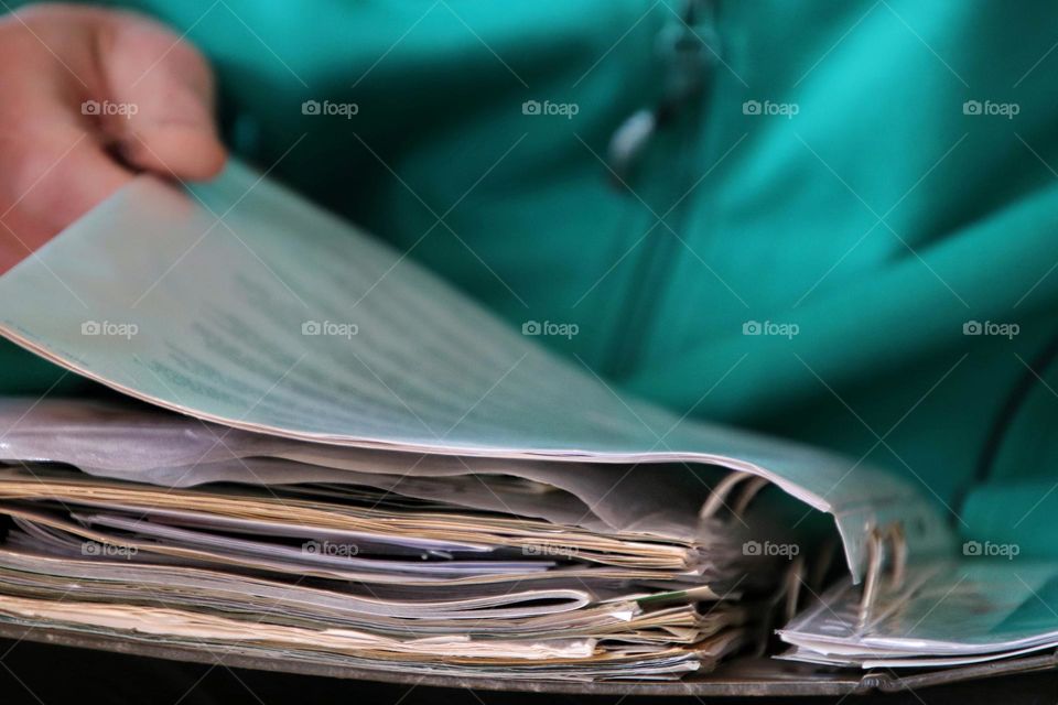 Close-up of a man's hand leafing through a folder