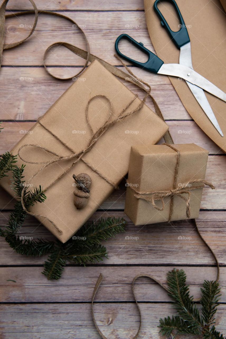 Natural flat lay of eco friendly wrapped Christmas gifts on a wooden floor 