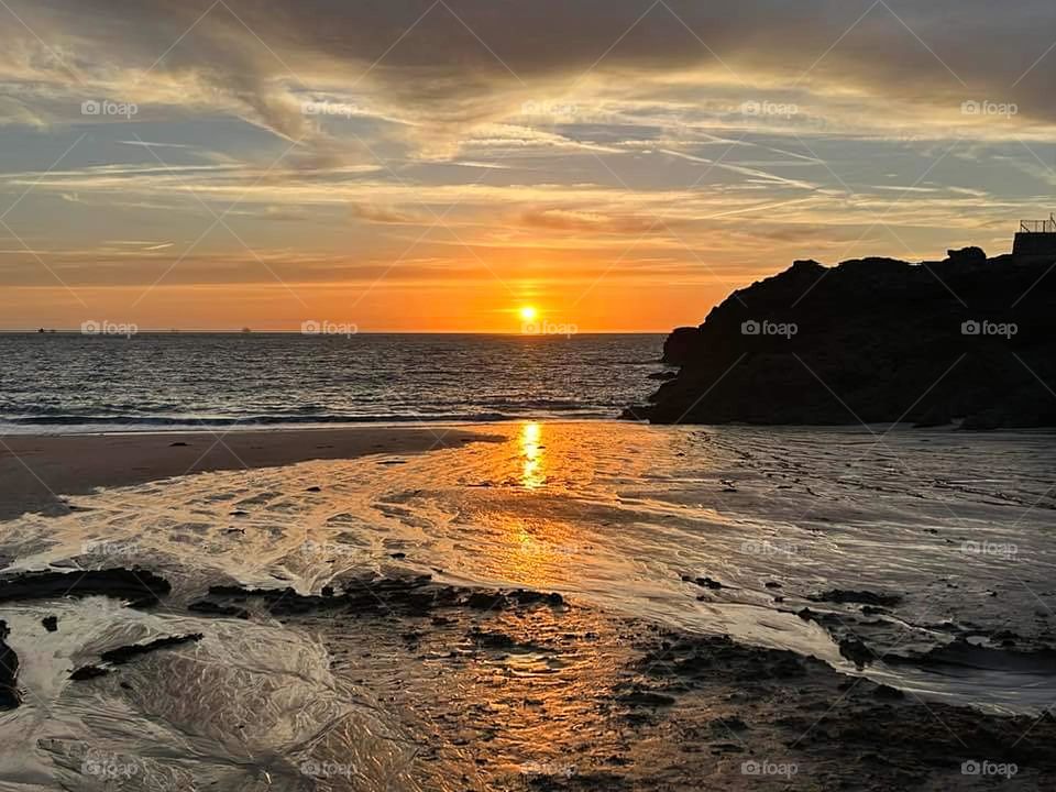 Sunset offering a gradient of orange, grey and brown colours on Nicet beach in Saint Malo