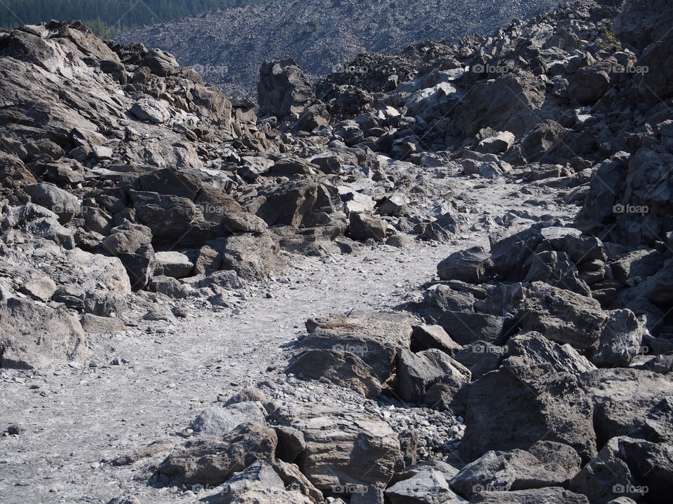 A path runs through the rugged terrain of the jagged rocks at the Big Obsidian Flow in the Newberry National Volcanic Monument in Central Oregon in the fall. 