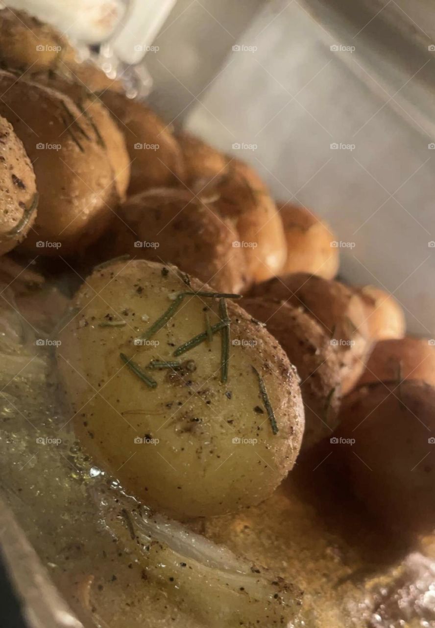 Delicious rosemary and butter covered baked potatoes roasting in the air fryer