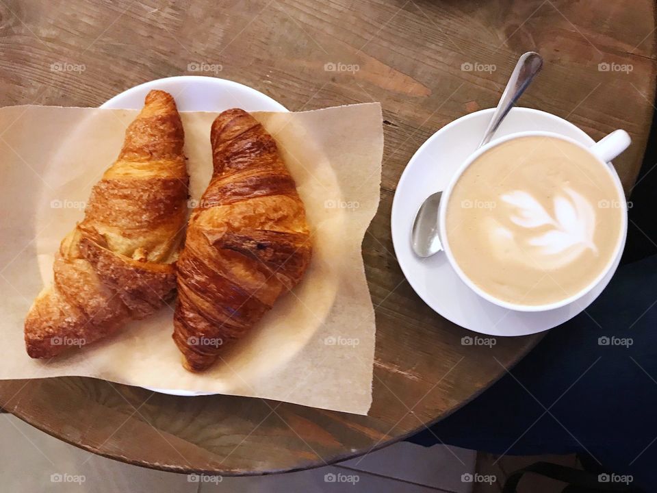 Breakfast with croissants and coffee on wood table top view 