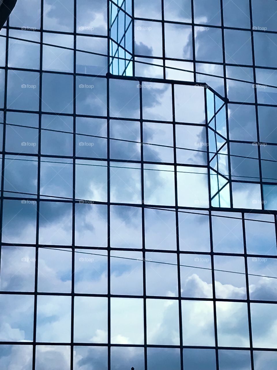Cloudy sky reflecting in a glass skyscraper 