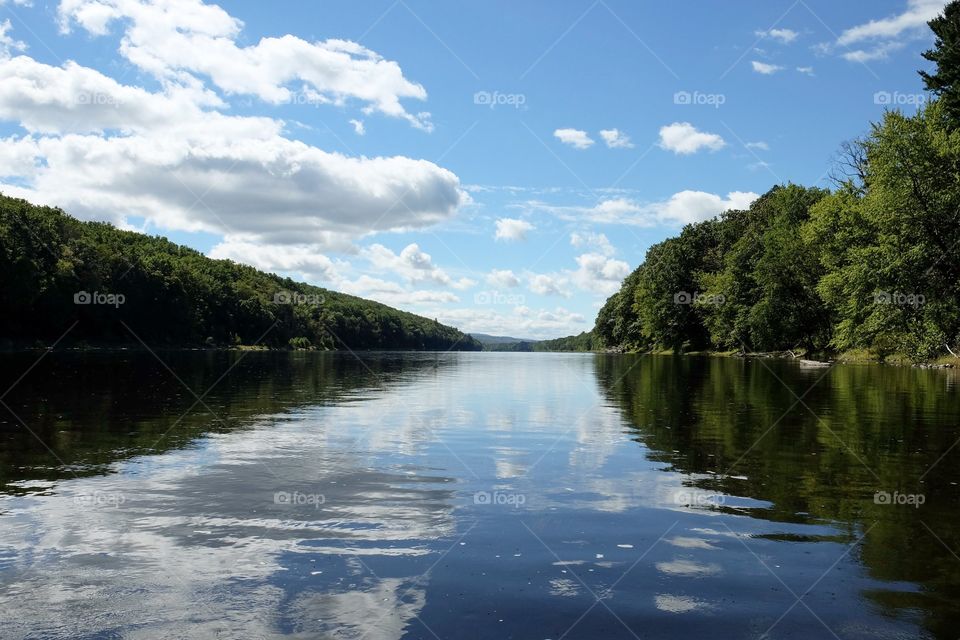 Trees and clouds reflecting on river