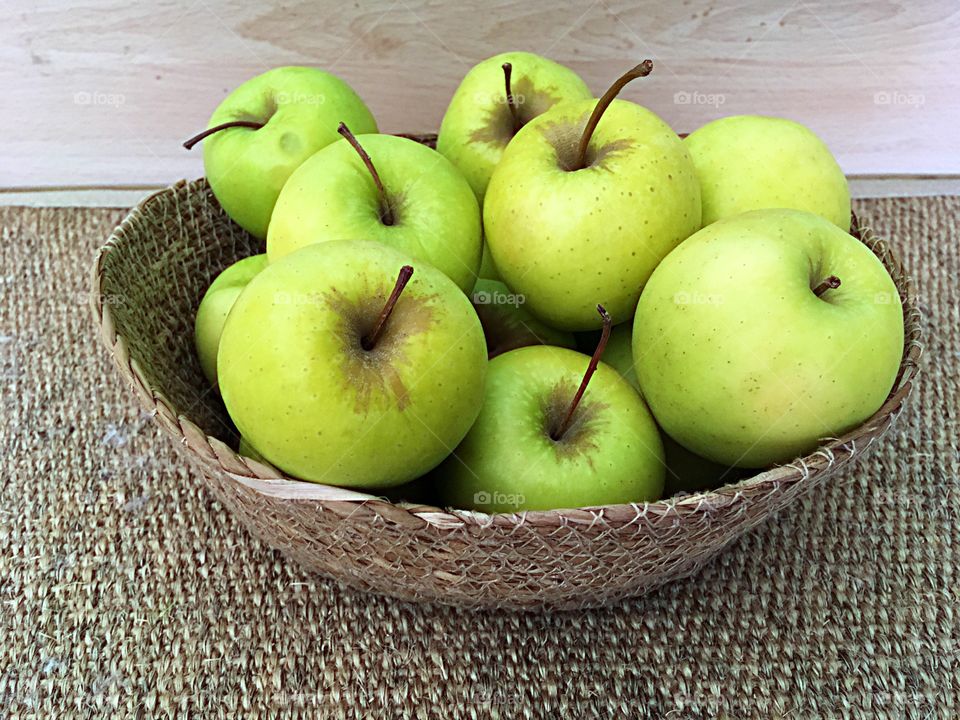 Basket of green apple on table