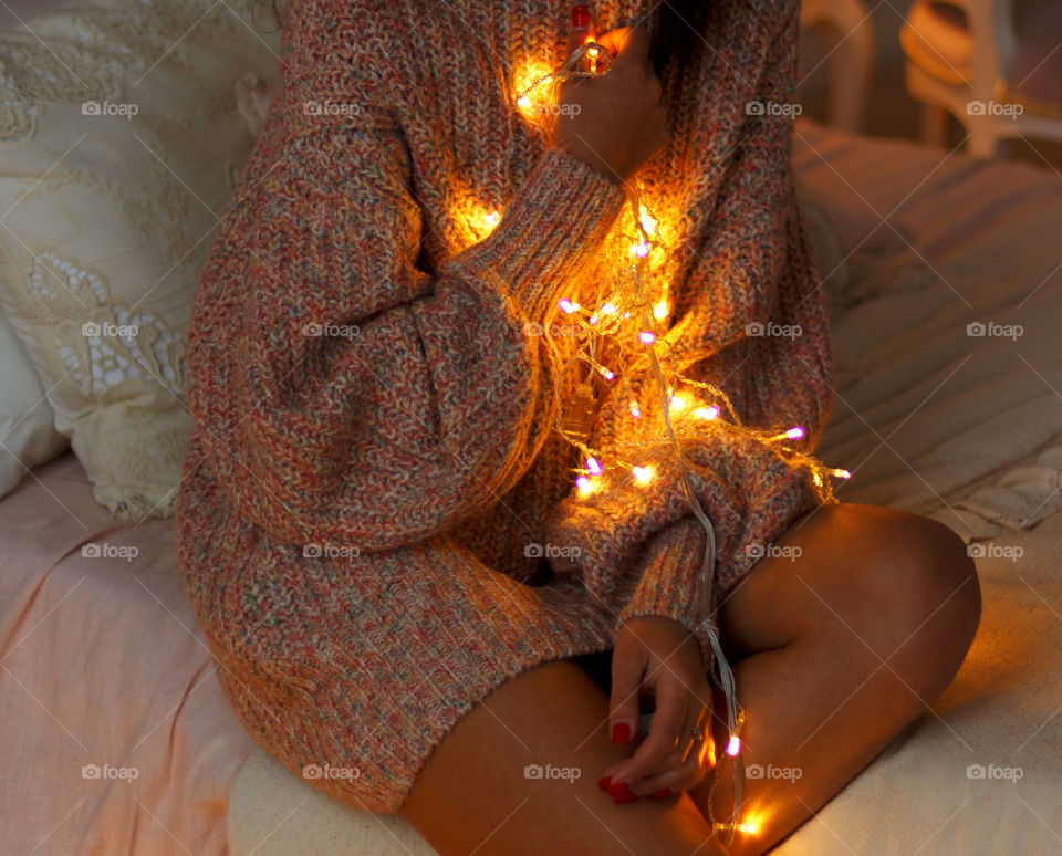 Girl with a lantern of lanterns sits on a bed