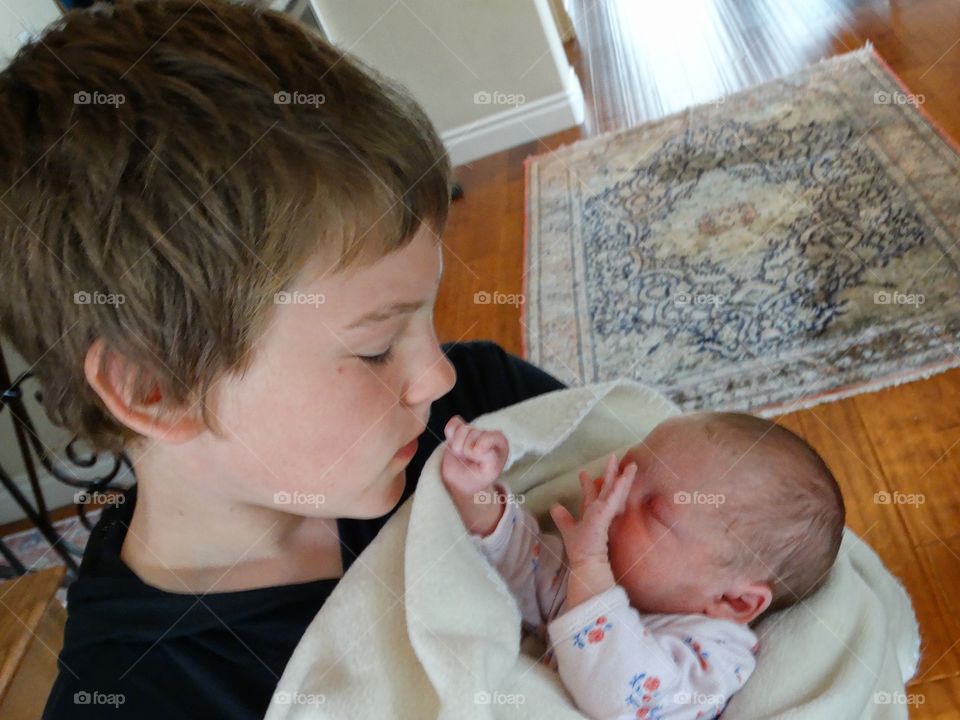 Young Boy Holding His Newborn Baby Sister
