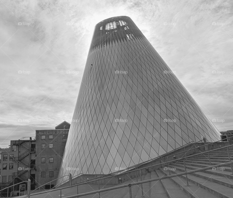 unique leaning metal tile covered cone shape modern architecture next to staircase