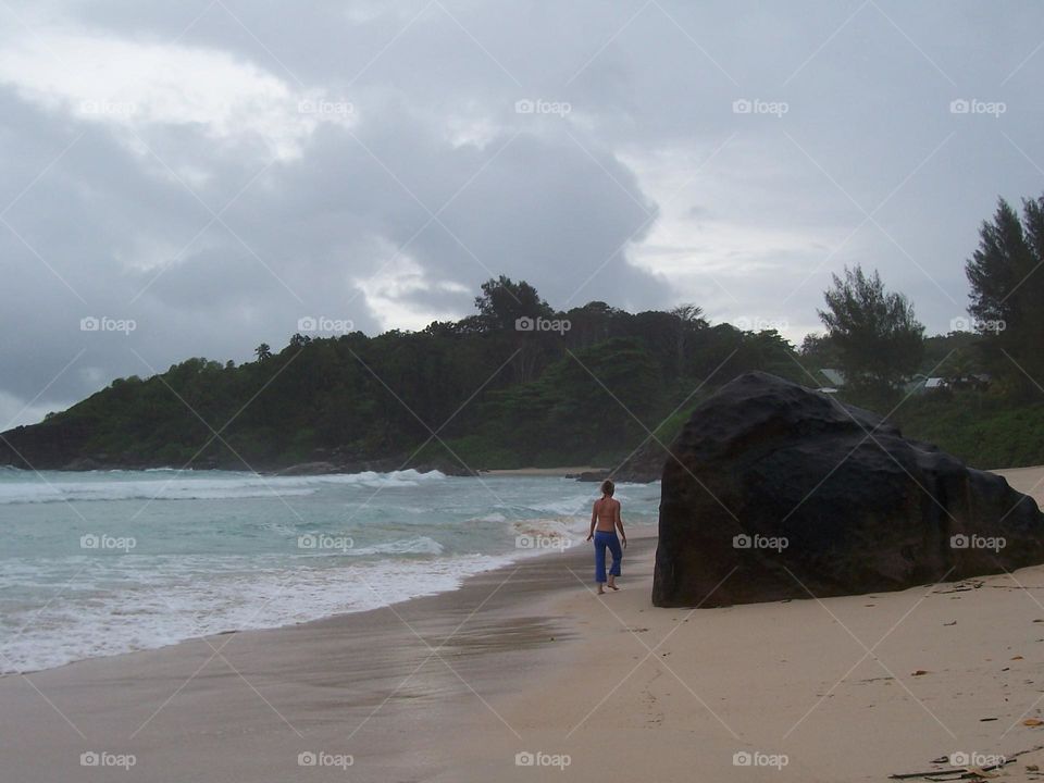 woman alone in beach, in rainy day