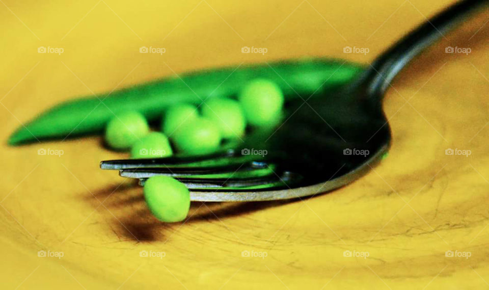 Peas. close-up of snow peas on a fork tine