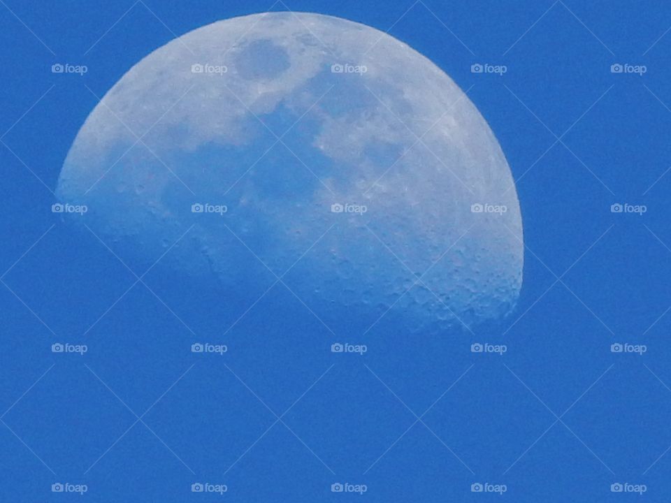 Daytime shot of the moon in a blue sky