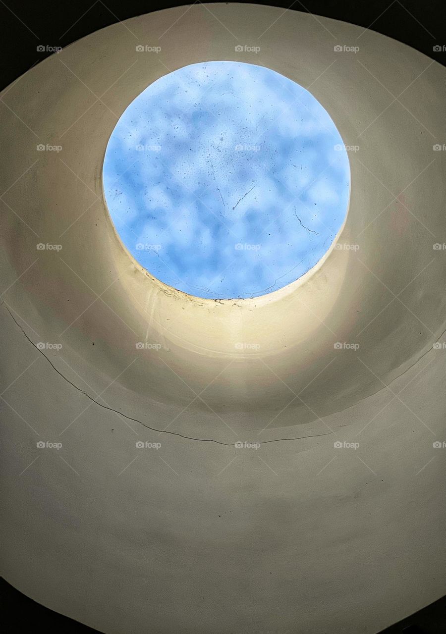 Sky with clouds see through round window 