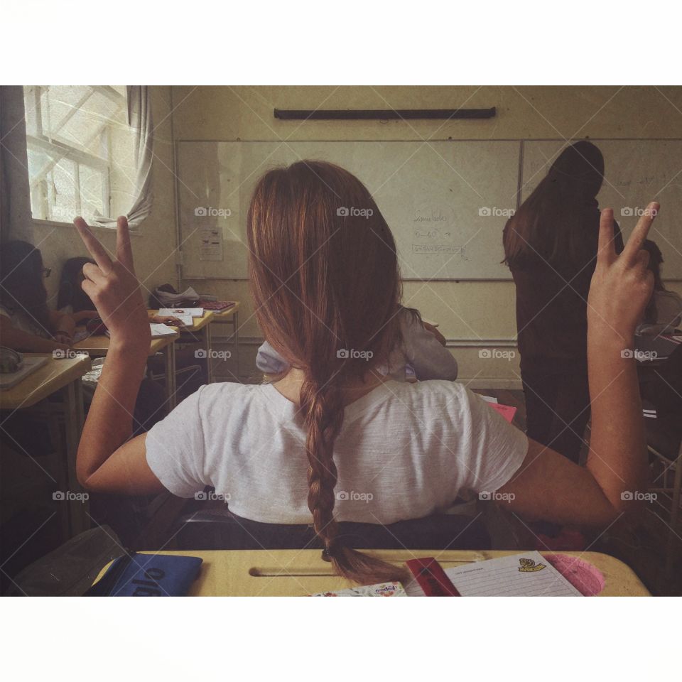 Rear view of a girl gesturing in classroom