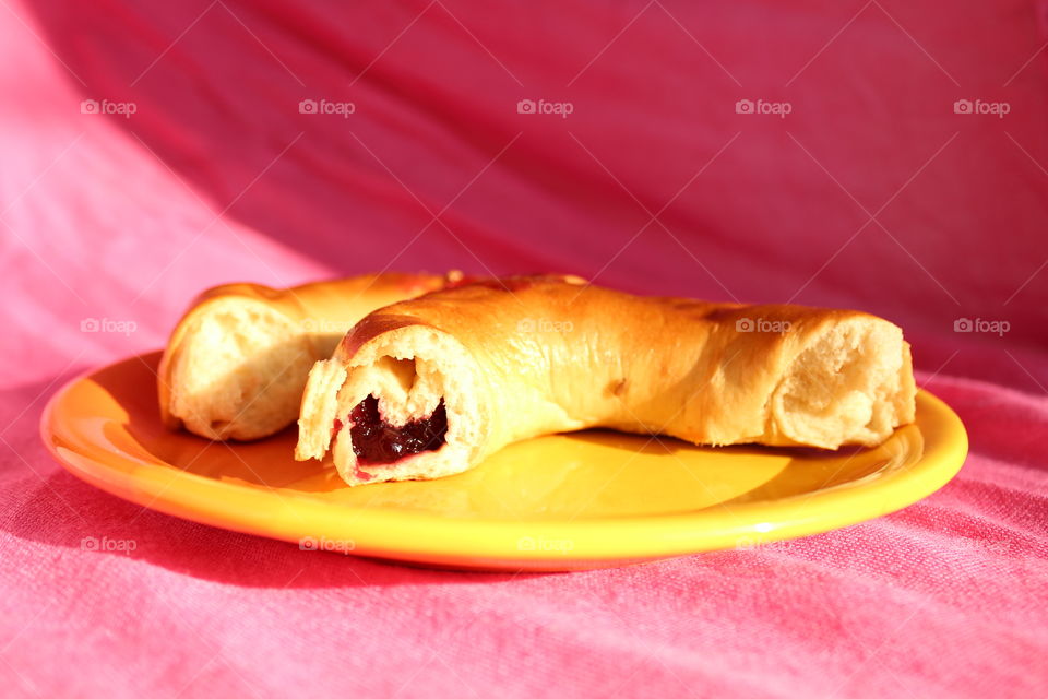 Miniature pie on a orange plate on pink background