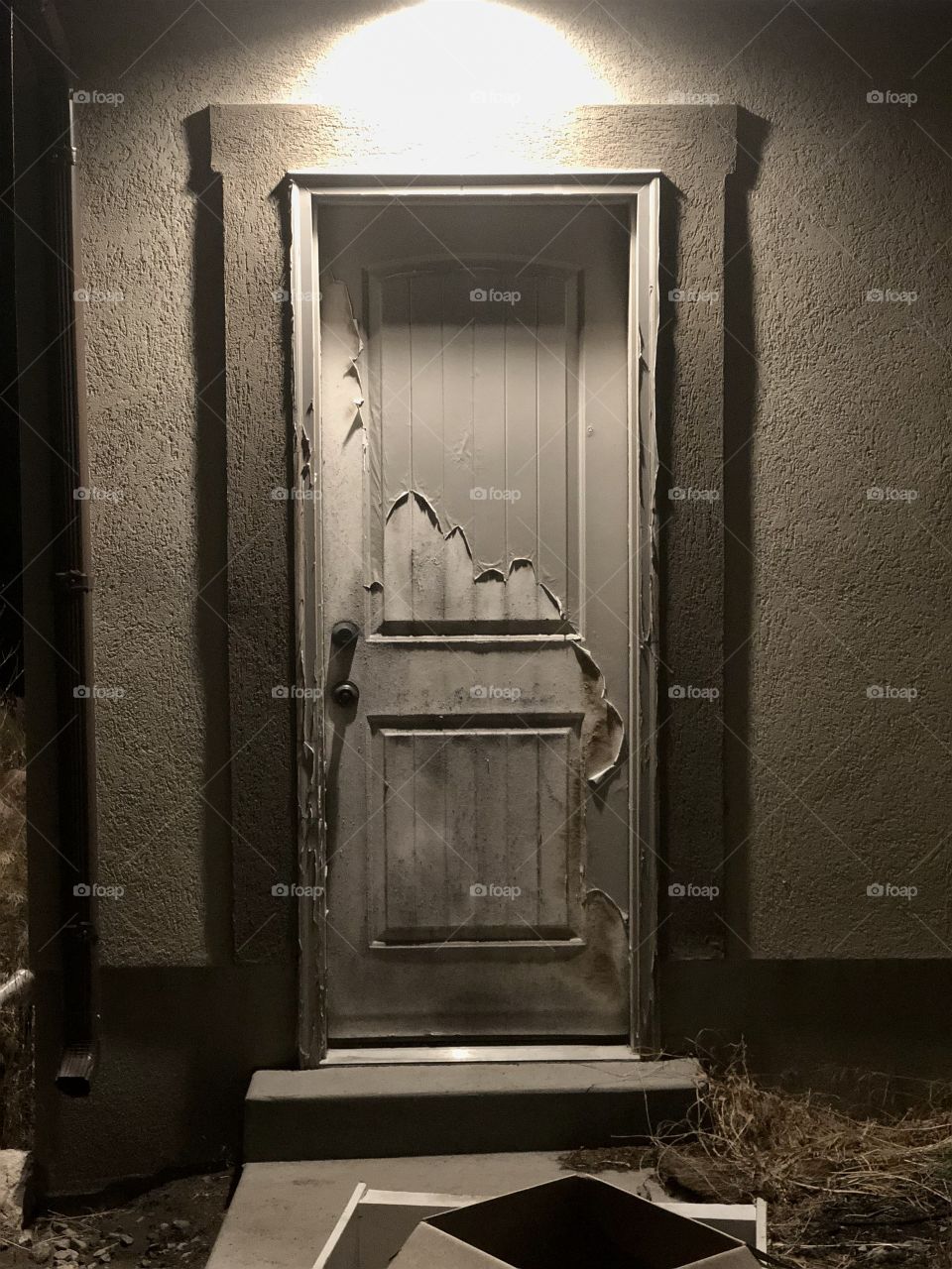 A 12-year-old, old weathered down door. An eerie combination of destruction and overhead lighting just after sunset.