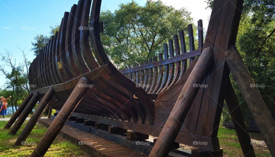 The bare bones of a ship sits next to the water it will never feel at Charlestown Landing in Charleston, South Carolina.