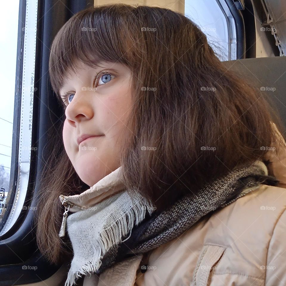 Cute girl riding the train. She is thinking about something, probably dreaming.